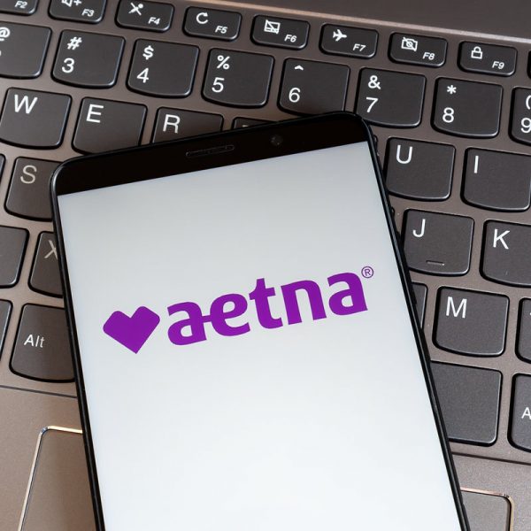 Toronto, On, Canada - February 27, 2021: Aetna logo on smartphone screen on keyboard. Aetna Inc. is an American managed health care company that sells health care insurance.