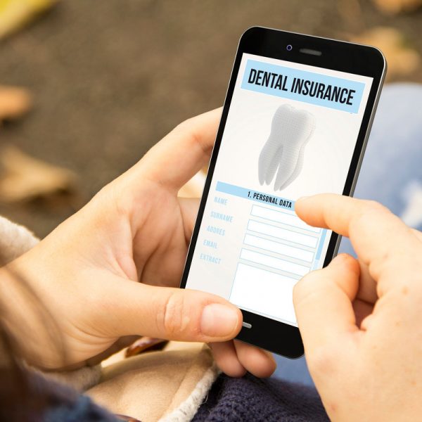 protection concept: woman holding a 3d generated smartphone with dental insurance on the screen. Graphics on screen are made up.